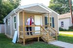 Brian Holland stands on the porch of his new home.