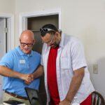 David Michael, the Executive Director of Huntington WV Area Habitat for Humanity, presents Brian Holland with the keys to his new home.
