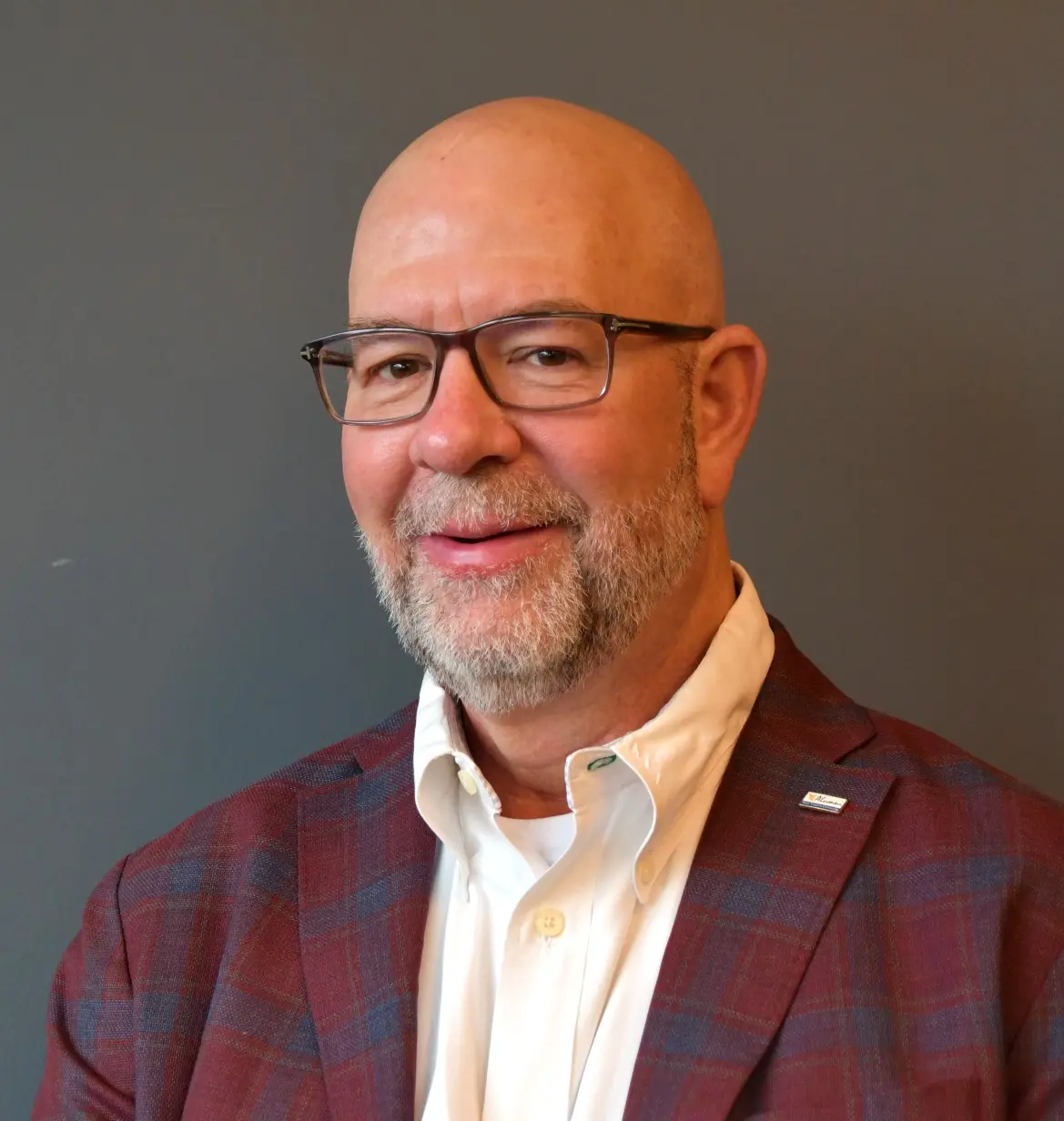 Professional headshot of Jon Rogers wearing glasses and business attire.