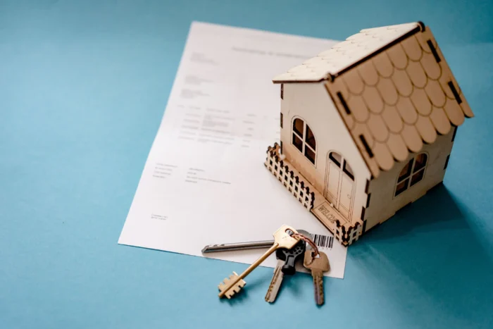 Model house and keys on a real estate document.